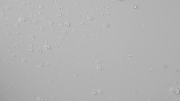 アクアエレメントクリエイティブ広告コンセプト 白い背景に透明なガラスのショットを閉じます 空気によって吹き飛ばされた表面の水滴の逆ショット抽象的なパターンを作成します — ストック動画