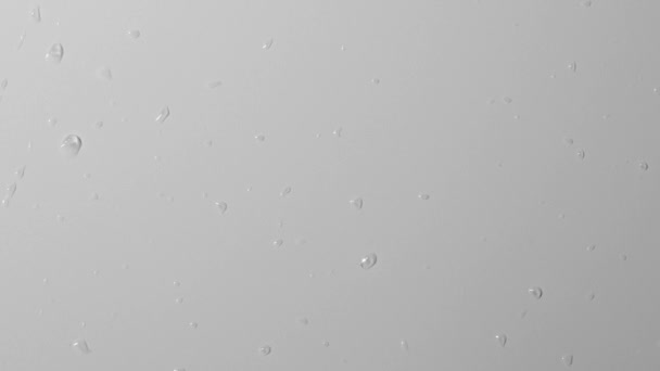 アクアエレメントクリエイティブ広告コンセプト グレーの背景にマットガラスのショットを閉じます 空気によって吹き飛ばされたモノクロの表面の水滴の逆ショット 抽象的なパターン — ストック動画