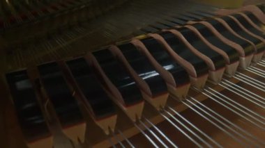 Müzik ve enstrümanlar yaratıcı reklam konsepti. Klasik piyanonun stüdyo çekimini kapat. Piyanonun içinde ahşap bir yüzeyle çekiçler tellere çarpıyor ve ses çıkarıyor..