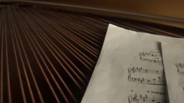 Müzik ve enstrümanlar yaratıcı reklam konsepti. Klasik piyanonun stüdyo çekimini kapat. Piyanonun içinde müzik notaları olan kompozisyon kağıtlarıyla çekilmiş.