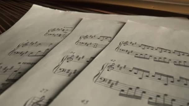 音乐和乐器创意广告的概念 关闭工作室拍摄古典钢琴 弹奏钢琴时 弹奏的是带着乐谱的作曲纸片 — 图库视频影像