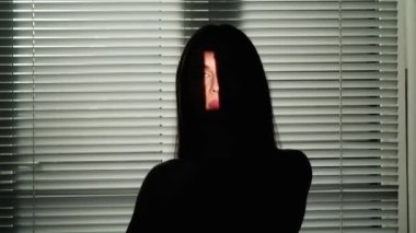 Vücut estetiği yaratıcı reklam konseptinin güzelliği. Stüdyoda çekici bir kadın modelin portresi. Esmer kadın. Yüzünde açık renk bir alan olan siyah siluet. Pencere kenarında duran külüstürle birlikte..