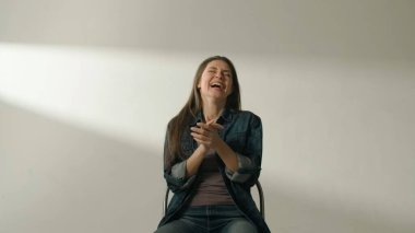 İnsan pozitif duyguları yaratıcı reklam kavramı. Cana yakın bir kadın modelin portresi. Esmer kadın, beyaz arka planda, stüdyoda mutlu bir şekilde el çırpıyor..