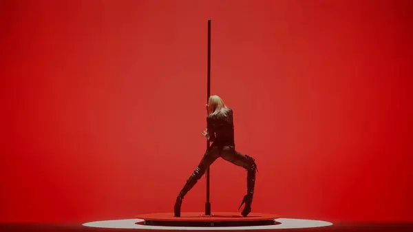 Modern dance style and choreography creative concept. Portrait of young female dancer in the studio. Professional pole dancer girl dancing on pylon, showing modern pole dance, red neon background.