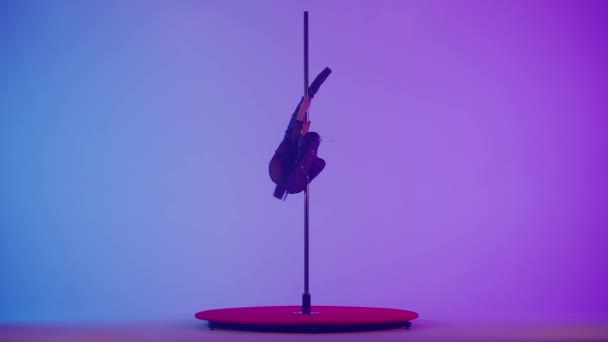 現代ダンススタイルと振付クリエイティブコンセプト スタジオの若い女性ダンサーの肖像画 プロのポールダンサーガールダンスは 現代のポールダンス ピンクの紫色の背景を示すピロンの上で踊ります — ストック動画