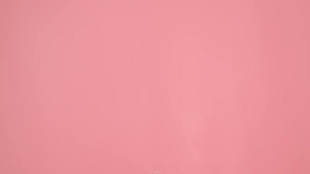 ピンク色の背景に撮られたクローズアップショットは 上から水に落ちる滴を表し それらが混ざってぼやけ 動きを作り出します あるいはあらゆる能力を発揮する — ストック動画