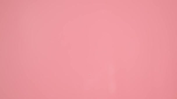Zbliżeniu Strzał Różowym Tle Reprezentowane Krople Które Spadają Góry Wody — Wideo stockowe