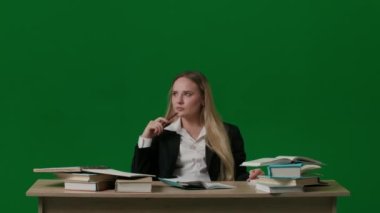 Beyin fırtınası ve problem çözme konsepti. Krom anahtar yeşil ekranda kadın portresi. Masada oturan kız, şüpheyle düşünüyor, fikir buluyor, parmağını kaldırıyor, kafasının üstünde lamba yanıyor..