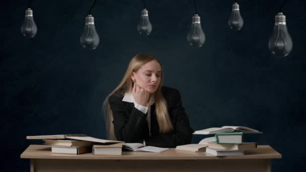 在问题解决中的想象力创造性概念 女孩在孤立的背景灯泡上的画像挂在顶部 女孩坐在桌子旁边想着心事 抬起头来发现有什么想法 就把手举起来 点着灯 — 图库视频影像