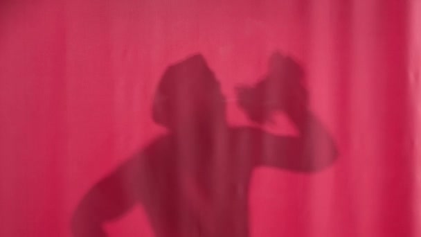 Silhouet Van Een Man Die Achter Een Roze Gordijn Wast — Stockvideo