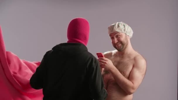 一个戴着粉色滑雪面罩的疯子偷偷地溜进他的受害者浴室 躲在浴帘后面 一个头戴防水帽的男人拍了一张凶手的照片 然后自拍了一张 那个疯子摆姿势要 — 图库视频影像