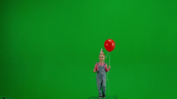 Malá Holčička Džínových Montérkách Slavnostní Čepicí Hlavě Červeným Heliovým Balónem — Stock video