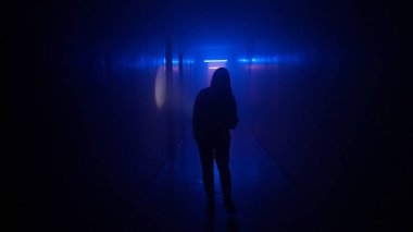 Terk edilmiş yerler ve boş binalar yaratıcı reklam konsepti. Karanlık koridorda neon ışıklı bir kadın portresi. Elinde fenerle koridorda yürüyen merdivenleri ve kapısı olan bir kadın..