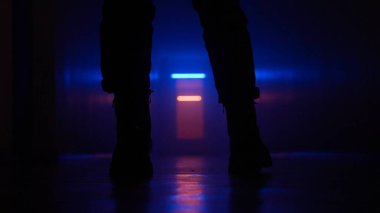 Terk edilmiş yerler ve boş binalar yaratıcı reklam konsepti. Karanlık koridor neon ışığındaki kadın. Zemindeki kızdan yakın çekim yalnız başına karanlık, boş koridorda yürüyor..