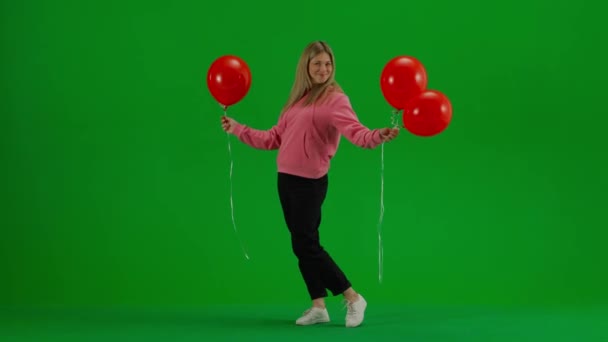 子どもと子育てのクリエイティブコンセプト スタジオで女性モデルの肖像画 立って 赤いヘリウム風船とポーズする女性 クロマキーグリーンスクリーンで楽しんで微笑んで背景を隔離 — ストック動画