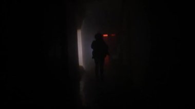 Terk edilmiş yerler ve boş binalar yaratıcı reklam konsepti. Karanlık koridorda kırmızı neon ışıklı bir kadın portresi. Elinde fenerle bodrumda hızla koşan bir kadın, kamera kızı kovalıyor.