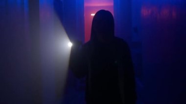 Terk edilmiş yerler ve boş binalar yaratıcı reklam konsepti. Karanlık koridorda neon ışıklı bir kadın portresi. Elinde fenerle koridorda yürüyen ve kapıları açmaya çalışan bir kadın..