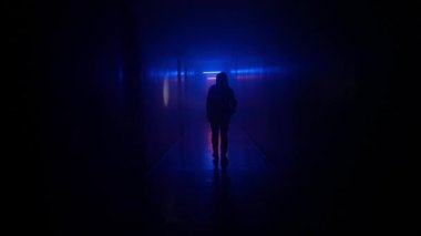 Terk edilmiş yerler ve boş binalar yaratıcı reklam konsepti. Karanlık koridorda neon ışıklı bir kadın portresi. Elinde fenerle koridorda yürüyen merdivenleri ve kapısı olan bir kadın..