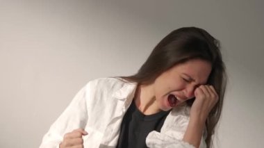 İnsani aşırı duygular yaratıcı reklam konsepti. Çekici kadın modelin olumsuz ruh hali portresi. Esmer kadının histerik bir ruh hali içinde bağıran, dokunan ve başını sallayan yüzünün stüdyo fotoğrafı..