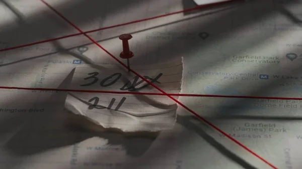 Criminology and forensic creative advertisement concept. Close up shot of investigation board. Detective board with map of crime scene, pinned note with numbers and red thread connecting clue proofs.