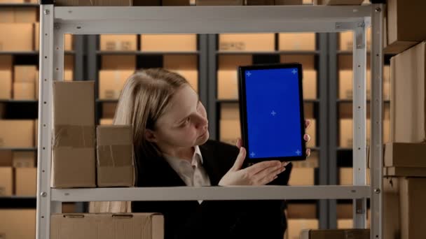 商务仓储和物流创新理念 在仓库工作的女性的肖像 仓库管理员穿着正装 靠近机架 装有装有蓝屏工作区模型的盒子 — 图库视频影像