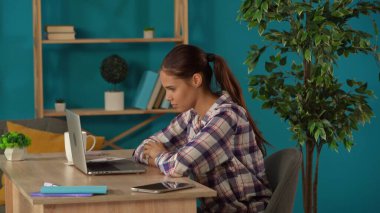 Bir kadını videoya çekerken orta ölçekli bir fotoğraf. Ev bilgisayarındaki biriyle konuşurken. Genç bayan programcı, iş kadını çalışıyor. Uzak iş, modern yaşam tarzı.