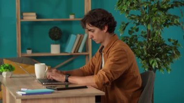 Bilgisayarda çalışan bir adamı yakalayıp evindeki tabletini kontrol ederken orta boy bir fotoğraf. Genç programcı, girişimci, işadamı, daktilo, bir proje üzerinde çalışıyor. Uzak iş, modern yaşam tarzı.