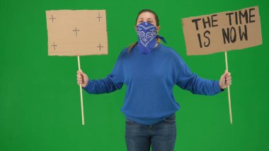 Eşarpla yüzünü kapatmış bir kadın gösterici elinde 