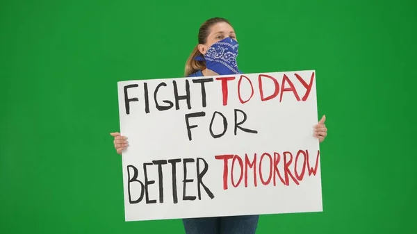 一位女权运动者举着一张标语牌 上面写着 为更美好的明天而奋斗 一个面部被围巾覆盖在绿色屏风上的女人 — 图库照片
