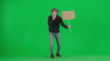 Adam megafona konuşuyor ve elinde boş bir levha tutuyor. Yeşil ekranda ağızlık ve afiş takan bir adam. Protesto eylemi, insan hakları için mücadele, grev. Reklam, promosyon, krom.
