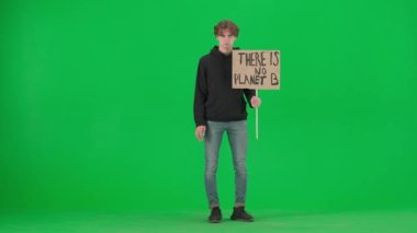 Genç bir erkek eylemci, B gezegeninin olmadığını belirten bir işaret gösterir ve tek eliyle dur hareketi yapar. Stüdyoda yeşil ekranda bir adam var. Gezegeni, küresel ısınmayı ve iklim değişikliğini kurtar