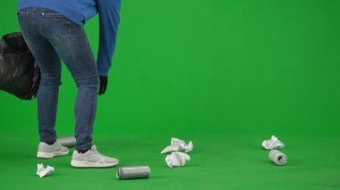 Siyah eldiven giyen ve çöp torbası taşıyan bir kadın gönüllü yeşil ekranda çöp topluyor. Kadın çöp torbasına kağıt ve teneke kutular koyuyor. Gönüllü ücretsiz iş yardımı