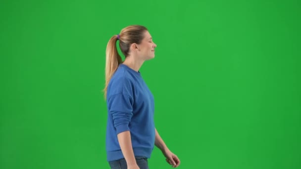 Πλευρική Άποψη Μιας Νεαρής Γυναίκας Που Περπατάει Μια Πράσινη Οθόνη — Αρχείο Βίντεο