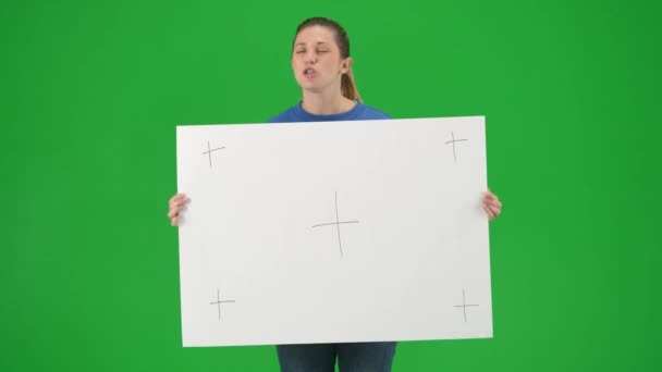 女权运动者手持一个大空白标语牌并发表演讲 女性在工作室的绿色屏幕上抗议 — 图库视频影像