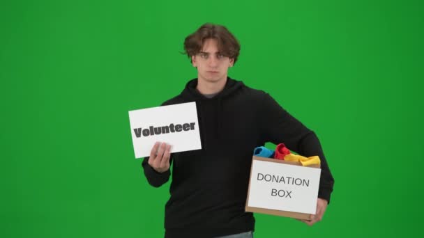 Ένας Άντρας Κρατά Μια Αφίσα Ετικέτα Εθελοντής Και Ένα Κουτί — Αρχείο Βίντεο