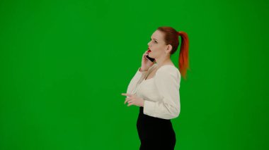 Modern iş kadını yaratıcı reklam konsepti. Krom anahtar yeşil ekranda çekici ofis kızı portresi. Etekli bir kadın akıllı telefondan konuşuyor.