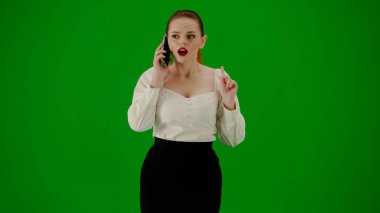 Modern iş kadını yaratıcı reklam konsepti. Krom anahtar yeşil ekranda çekici ofis kızı portresi. Etek ve bluz giyen bir kadın akıllı telefondan konuşuyor, pozitif yüz ifadesi..