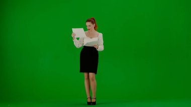 Modern iş kadını yaratıcı reklam konsepti. Krom anahtar yeşil ekranda çekici ofis kızı portresi. Etek ve bluz giyen kadın doküman okuyor, kafası karışmış yüz ifadesiz..