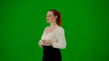 Modern iş kadını. Krom anahtar yeşil ekranda çekici ofis kızı portresi. Etek ve bluz giyen, gülümseyen, fincandan kahve içen bir kadın. Yarım dönüş..