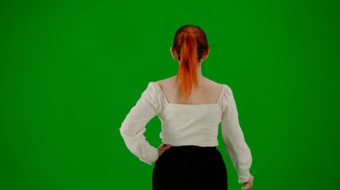 Modern iş kadını yaratıcı reklam konsepti. Krom anahtar yeşil ekranda çekici ofis kızı portresi. Etek ve bluz giyen kadın kurnazca yürüyor. Arka plan.