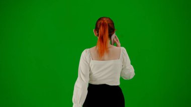 Modern iş kadını. Krom anahtar yeşil ekranda çekici ofis kızı portresi. Etek ve bluz giyen bir kadın akıllı telefondan konuşuyor. Arka plan.