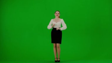 Modern iş kadını yaratıcı reklam konsepti. Krom anahtar yeşil ekranda çekici ofis kızı portresi. Etek ve bluz giymiş bir kadın kameraya doğru konuşuyor, kendine güveni tam bir yüz ifadesi.