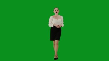 Modern iş kadını yaratıcı reklam konsepti. Krom anahtar yeşil ekranda çekici ofis kızı portresi. Etek ve bluz giymiş bir kadın kameraya doğru yürüyor, olumlu bir ifade..