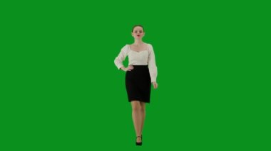 Modern iş kadını yaratıcı reklam konsepti. Krom anahtar yeşil ekranda çekici ofis kızı portresi. Etekli ve bluzlu bir kadın güvenle yürüyor, elleri belinde kameraya bakıyor.