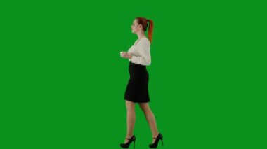 Modern iş kadını. Krom anahtar yeşil ekranda çekici ofis kızı portresi. Etek ve bluz giyen, gülümseyen, fincandan kahve içen bir kadın. Yan görünüm.