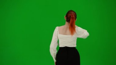 Modern iş kadını yaratıcı reklam konsepti. Krom anahtar yeşil ekranda çekici ofis kızı portresi. Etekli ve bluzlu kadın sanal menüyü kullanıyor, bakıyor ve araklıyor..