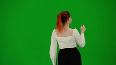 Modern iş kadını yaratıcı reklam konsepti. Krom anahtar yeşil ekranda çekici ofis kızı portresi. Etekli ve bluzlu kadın sanal menüyü kullanıyor, bakıyor ve araklıyor..