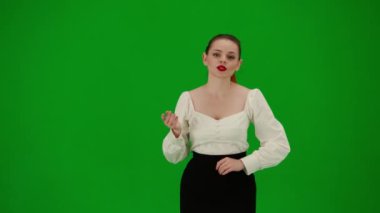 Modern iş kadını yaratıcı reklam konsepti. Krom anahtar yeşil ekranda çekici ofis kızı portresi. Etek ve bluz giymiş bir kadın kameraya doğru konuşuyor, kendine güveni tam bir yüz ifadesi.