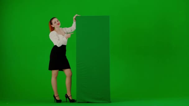 現代のビジネス女性クリエイティブ広告コンセプト クロマキーグリーンスクリーンの魅力的なオフィスガールの肖像画 スカートと緑の広告ボードを指すブラウスの女性は 親指を示しています — ストック動画