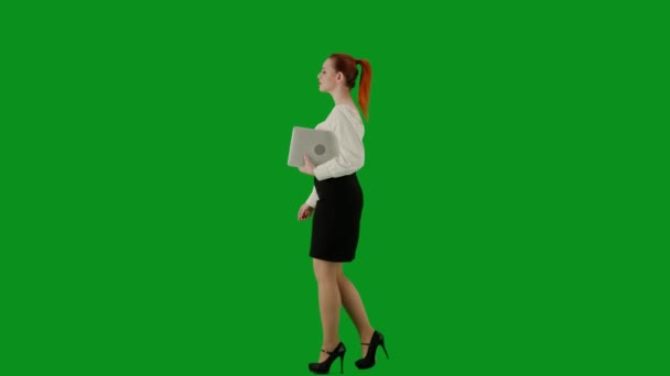 現代のビジネス女性クリエイティブ広告コンセプト クロマキーグリーンスクリーンの魅力的なオフィスガールの肖像画 スカートの女性とラップトップを持って歩くブラウス サイドビュー — ストック動画